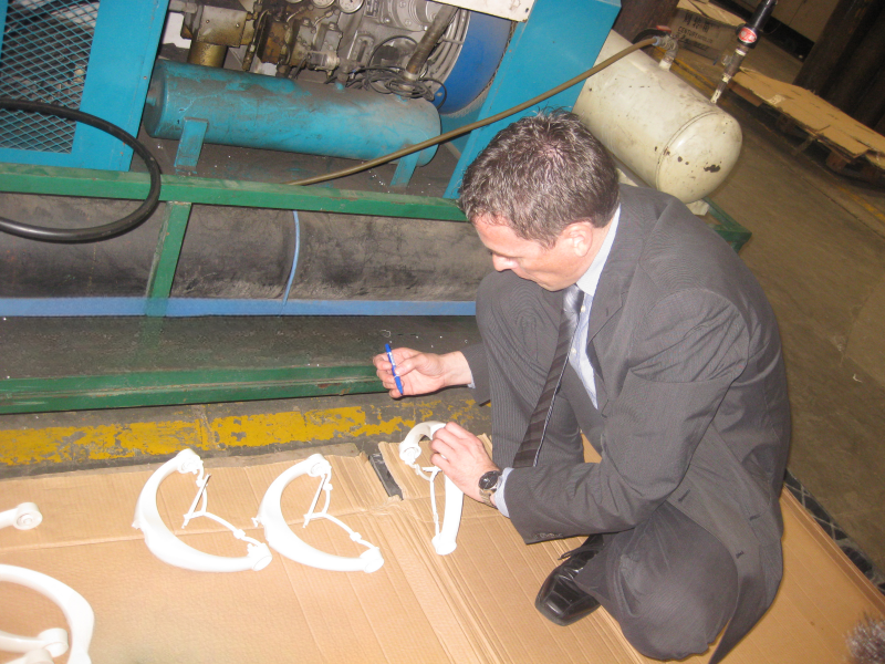 Person reviewing white molded samples in a workshop setting