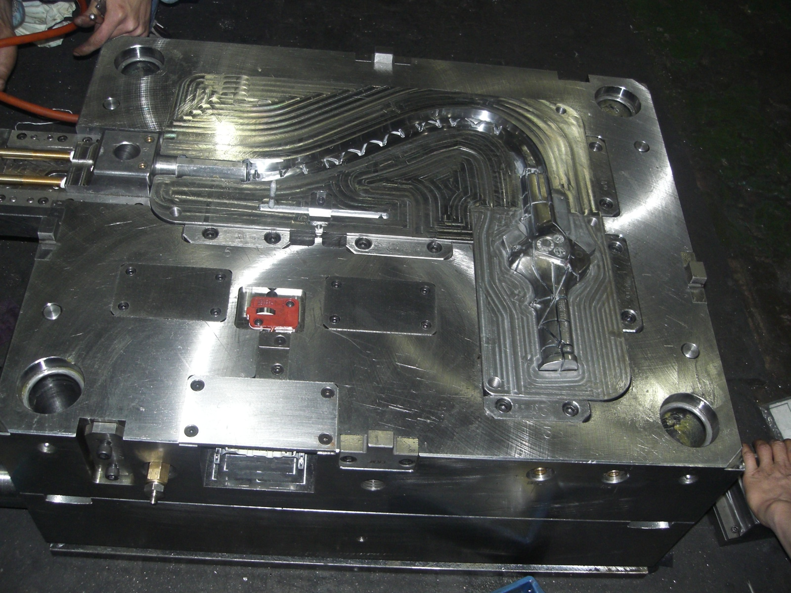 Polished steel mold half with a long curved cavity